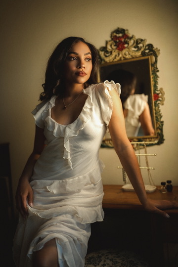 Kierra Sari seated beside a vintage mirror